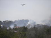 A helicopter dumps water onto a wildfire Wednesday, March 30, 2022, in Sevierville, Tenn.