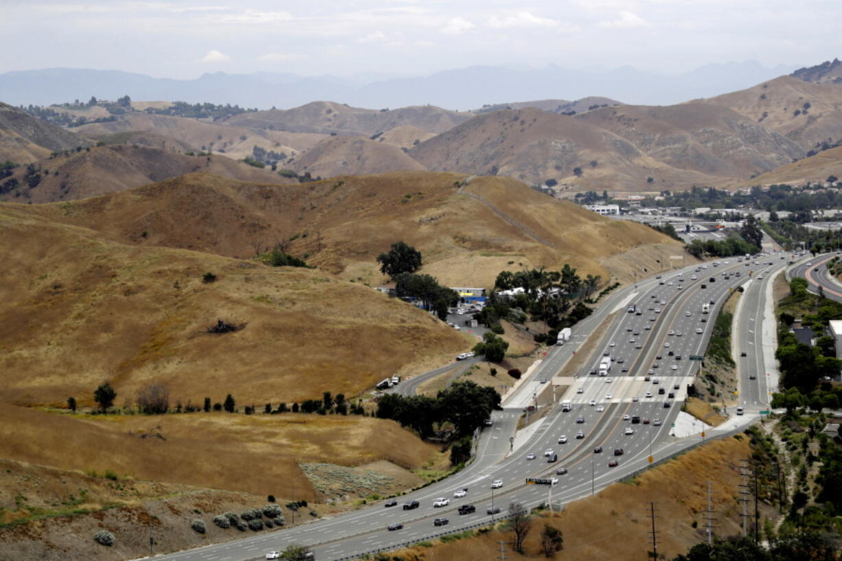 FILE - U.S. Highway 101 passes between two separate open space preserves on conservancy lands in the Santa Monica Mountains in Agoura Hills, Calif., July 25, 2019. Groundbreaking is set for next month on what will be the world's largest wildlife crossing, a bridge over a major Southern California highway that will provide more room to roam for mountain lions and other animals hemmed in by urban sprawl. A ceremony marking the start of construction for the span over U.S. 101 near Los Angeles will take place on Earth Day, April 22, the National Wildlife Federation announced on Thursday, March 24, 2022.