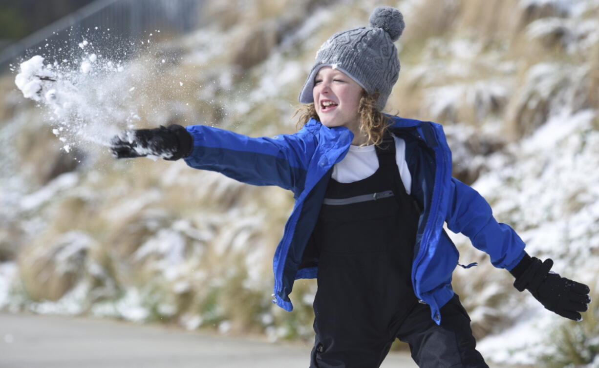 Ian Mattson, 9, throws a snowball at his sister Elise, 5, as they play in Renaissance Park on Saturday, March 12, 2022 In Chattanooga, Tenn.