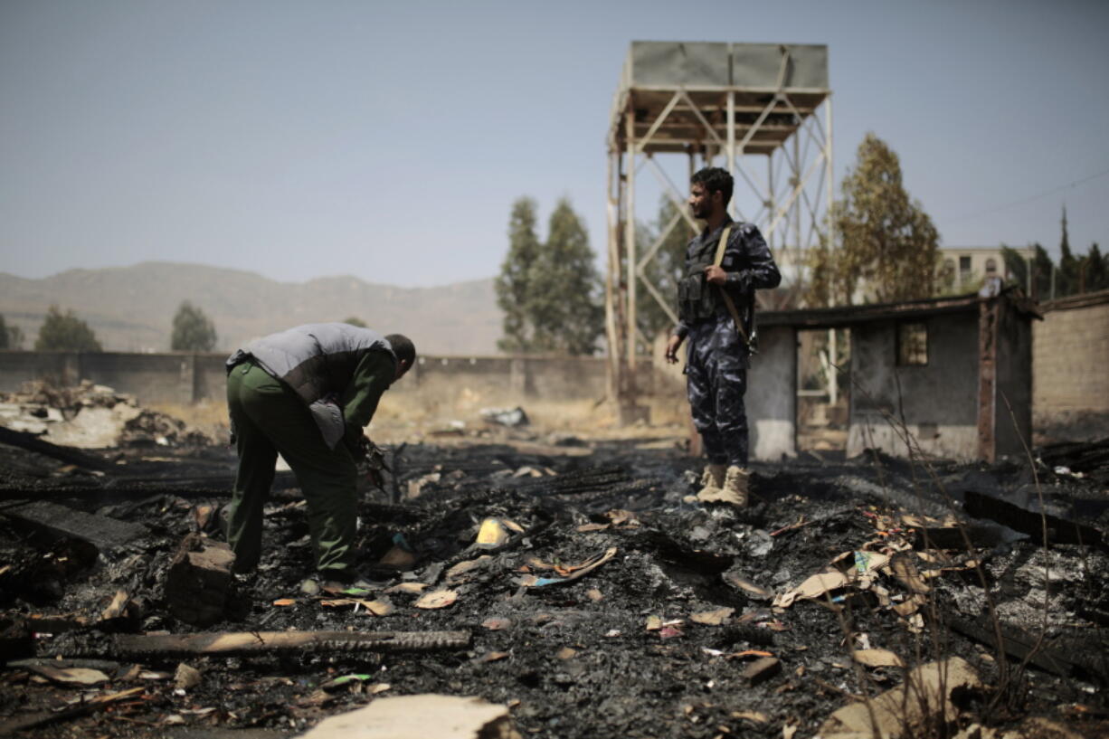 Yemeni police inspect a site of Saudi-led airstrikes targeting two houses in Sanaa, Yemen, Saturday, March 26, 2022. A Houthi media office claimed an airstrike hit houses for guards of the social insurance office, killing at least seven people and wounding three others, including women and children.