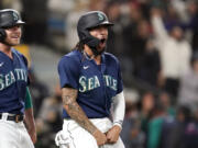 Seattle Mariners' J.P. Crawford, right, celebrates with Jake Bauers after both scored against the Los Angeles Angels in the eighth inning of a baseball game Saturday, Oct. 2, 2021, in Seattle.