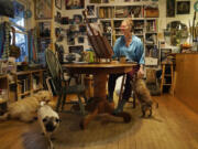 Artist Kat Corrigan works on one of her paintings for her 30 cats in 30 days project from her home, as family dogs rest and stir around her, Tuesday, March 15, 2022, in Minneapolis.