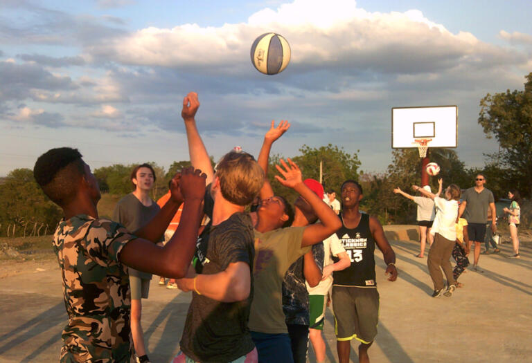 Courts For Kids volunteers and youths from El Rodeo, Dominican Republic, play basketball on a recently finished sports court on April 7.