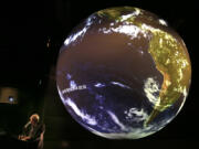 Aquarium Of The Pacific President Dr. Jerry Schubel gathers his notes prior to a discussion on the El Nino weather phenomenon at the Aquarium Of The Pacific in Long Beach, California, while projecting images of the weather patterns on their Science On A Sphere exhibit, Nov. 13, 2014.