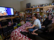 Emily Brooke Holth (middle) and her daughter Kaia, 24, watch a DVR movie with Kaia's twin brother Ry who has Down's Syndrome, on March 31, 2022, in Monrovia, California.