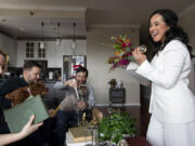 Rachel Ambrozewski, right, and Evan Cooperman, second from right, look over their planned decorations April 10 with bridesmaid Ryann Rase, left, and groomsman Chris Robinson at their Chicago home. The couple were forced to cancel their wedding plans multiple times during the pandemic and have rescheduled their celebration for June.