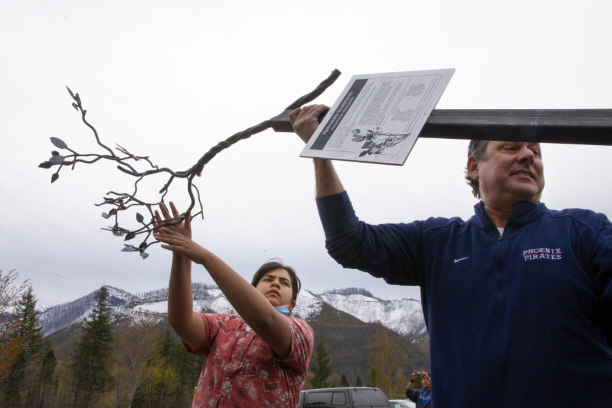 Student Aaron Chavez, 14, left, and Phoenix-Talent School District Superintendent Brent Barry deliver a metal sculpture of a Manzanita tree branch to McKenzie High School in Blue River.