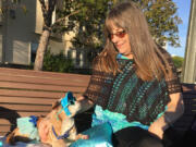 Diana McAllister lounges with her dog, Honey, at a park in San Francisco. Some pet owners in the area report waiting months for veterinarian appointments.