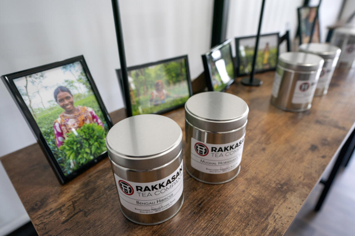 Canisters of Rakkasan Tea sit in front of photos of tea growers from the countries where the tea was sourced Friday, April 23, 2021, at the company's new brick-and-mortar store, in Dallas.