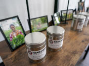 Canisters of Rakkasan Tea sit in front of photos of tea growers from the countries where the tea was sourced Friday, April 23, 2021, at the company's new brick-and-mortar store, in Dallas.