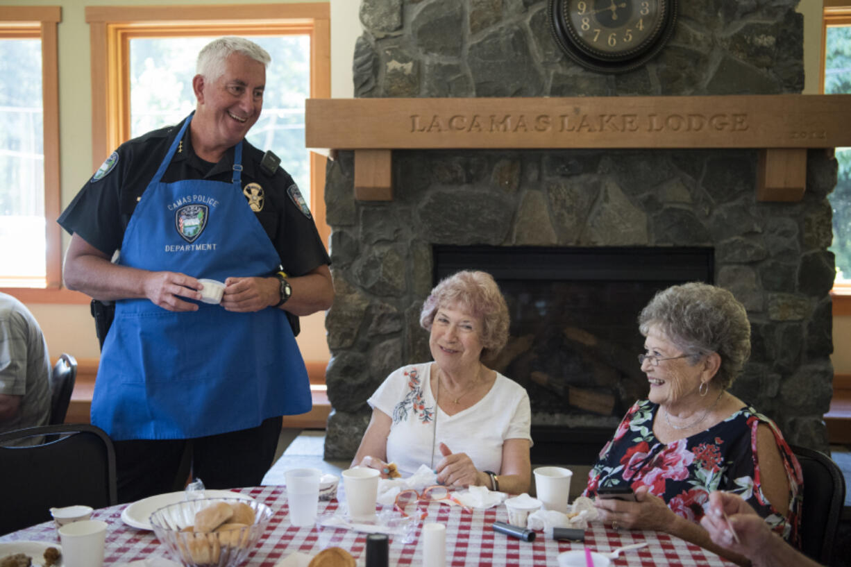 Camas Police Chief Mitch Lackey, from left, hands out ice cream to Irene Cole and Carrie Glaser, both of Vancouver, during the Seniors and Law Enforcement Together annual picnic at the Lacamas Lake Lodge in Camas on July 23, 2018.