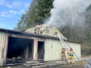 A commercial building caught fire Friday afternoon in Woodland. Arriving fire crews found a man dead outside whom the Clark County Fire Marshal's Office said was thrown from the building in an explosion.