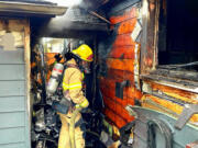 Vancouver firefighters extinguish a garage fire Saturday in the Shumway neighborhood. The homeowners told firefighters everyone escaped the house safely, and no one was injured.