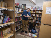 Lucas Gubala, left, and Sarah Summerhill, co-owners of the vintage bookstore Birdhouse Books, sort through books in their shop on Main Street in downtown Vancouver.