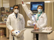 Pulmonologist Dr. Bhanu Patibandla, left, and thoracic surgeon Dr. Svetlana Kotova stand for a portrait with an Ion Endoluminal System device at PeaceHealth Southwest Medical Center in Vancouver. The device allows Patibandla to locate and biopsy lung masses that are less then a centimeter in size, a tenth of what could traditionally be located and biopsied before. Using the device, Patibandla and Kotova developed a dual procedure where they perform a lung biopsy and remove the mass in a single operation, providing a diagnosis and treatment with one procedure instead of two.