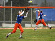 Ridgefield freshman Charlie Harris, left, catches the ball Friday, April 1, 2022, during the Spudders' 10-1 win against R.A. Long at Ridgefield High School.