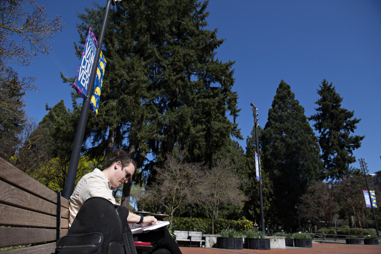 Kevin Gilgan, who lives in Sandy but works in Vancouver, relaxes on his lunch break near a grove of trees at Esther Short Park on Thursday. The Heritage Tree program highlights dozens of Vancouver's Heritage trees that bore witness to the evolution of the city.