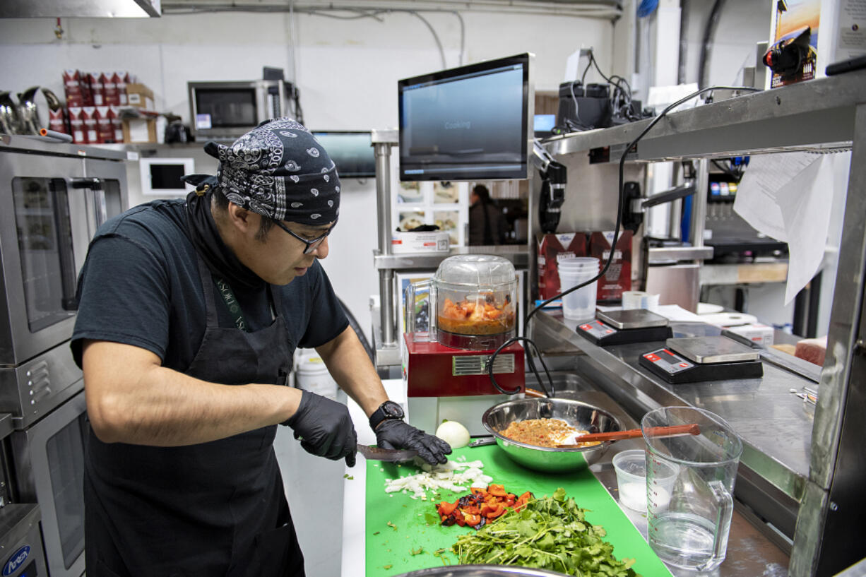 Line cook Aaron Mata-Silva of Diosa chops ingredients to make salsa in downtown Vancouver on Monday afternoon.