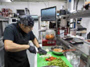 Line cook Aaron Mata-Silva of Diosa chops ingredients to make salsa in downtown Vancouver on Monday afternoon.