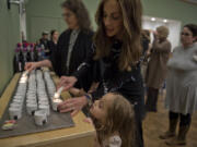 Tzivie Greenberg, and her daughter, Kenya, 4, light candles for the start of Passover ceremonies at a Passover Seder held Friday evening at  at Chabad Jewish Center of Clark County.