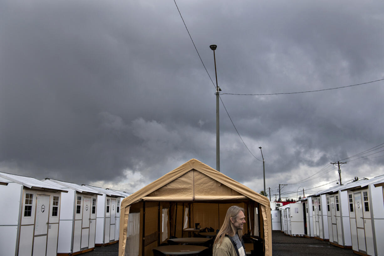 Storm clouds roll in as Charles Stuart, a future on-site manager of Vancouver's second Safe Stay Community, talks to the media about the shelter program Wednesday. At each temporary housing location, residents have access to local social services to help them recover from homelessness and transition into permanent housing.