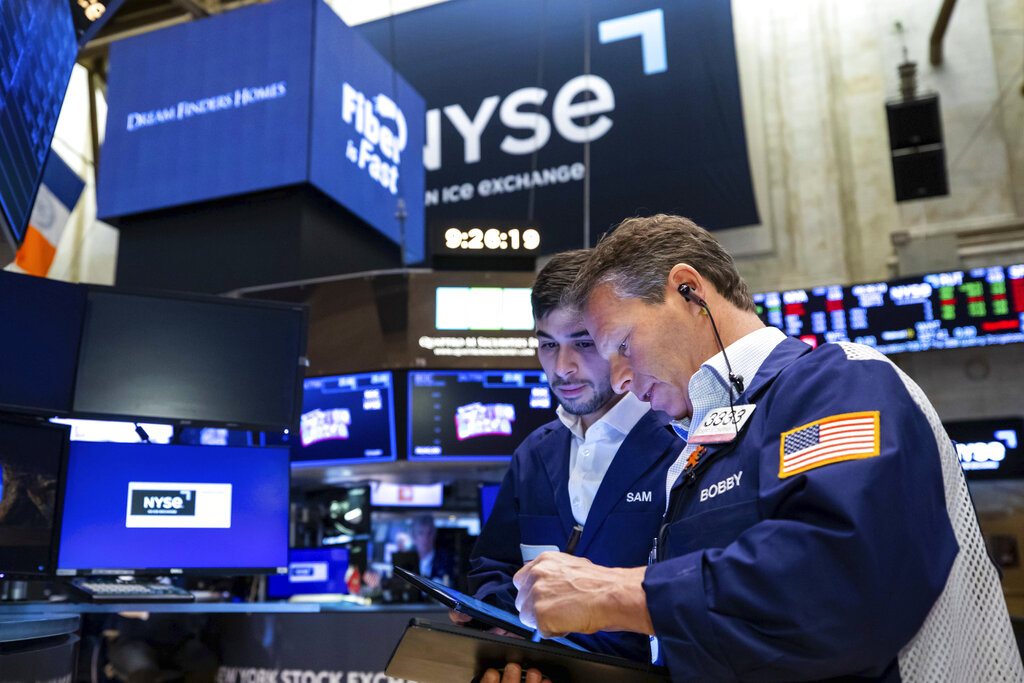 In this photo provided by the New York Stock Exchange, Robert Charmak, right, works with a colleague on the trading floor, Monday, April 11, 2022. Stocks fell in afternoon trading on Wall Street Monday as the market extends a losing streak from last week. (David L.