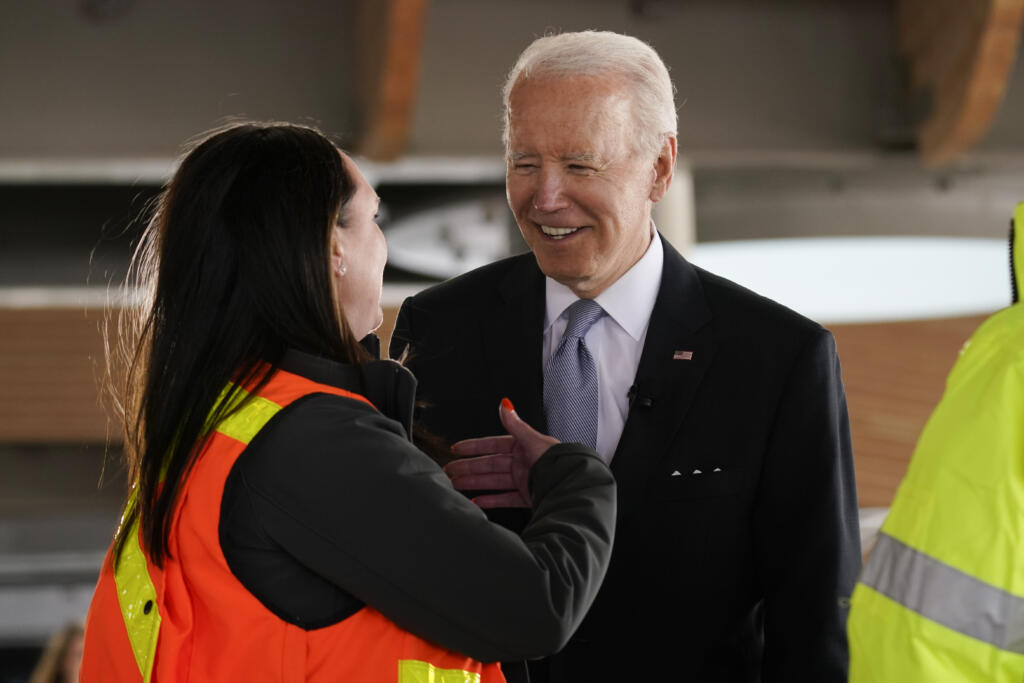 President Joe Biden listens as he tours a construction area at Portland International Airport, Thursday, April 21, 2022, in Portland, Ore.