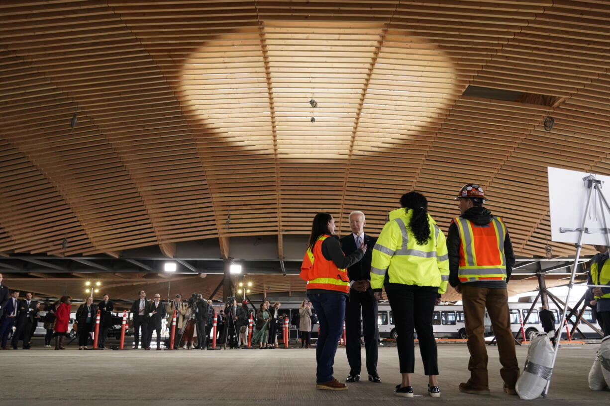 President Joe Biden listens as he tours a construction area at Portland International Airport, Thursday, April 21, 2022, in Portland, Ore.