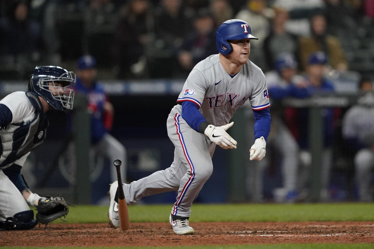 Texas Rangers' Kole Calhoun watches his RBI double during the ninth inning of the team's baseball game against the Seattle Mariners, Thursday, April 21, 2022, in Seattle. (AP Photo/Ted S.