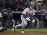 Texas Rangers' Kole Calhoun watches his RBI double during the ninth inning of the team's baseball game against the Seattle Mariners, Thursday, April 21, 2022, in Seattle. (AP Photo/Ted S.