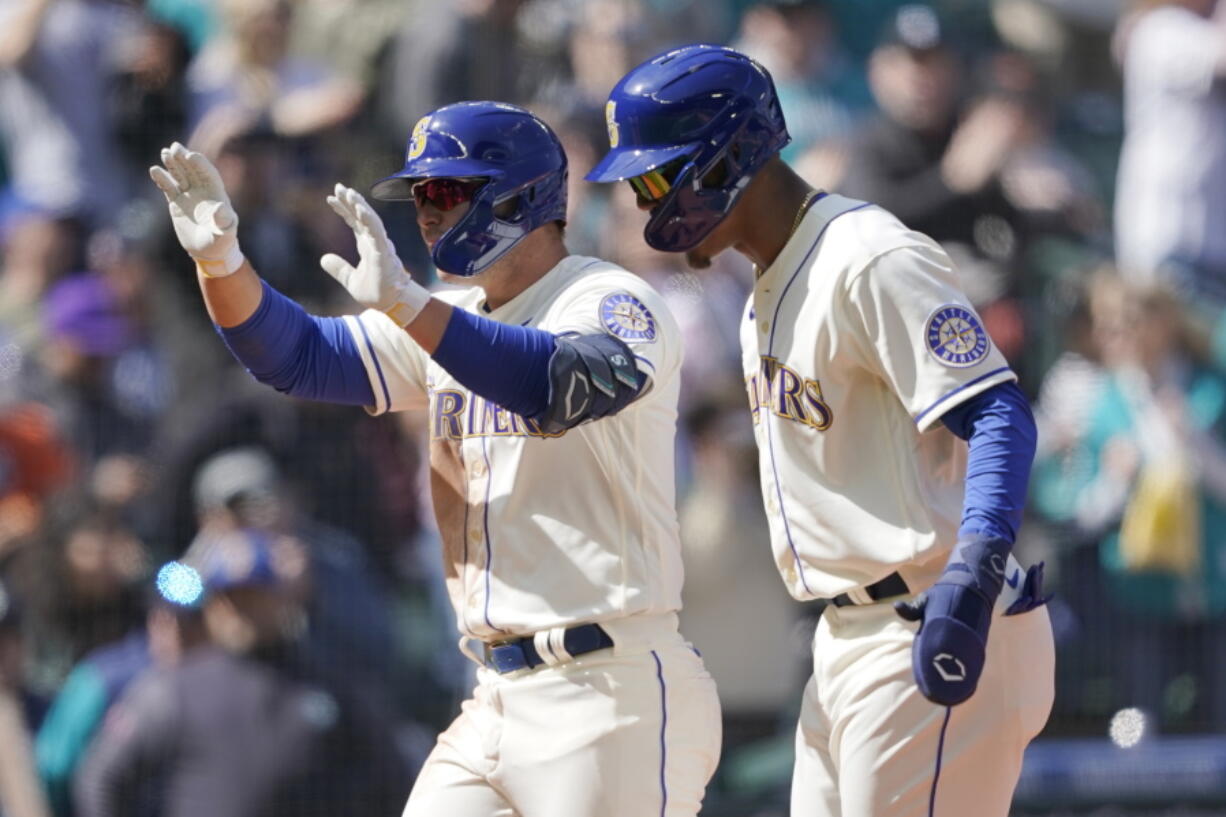 Seattle Mariners' Ty France left, reacts with Julio Rodriguez, right, after France hit a three-run home run to score Rodriguez and Adam Frazier during the fourth inning of a baseball game against the Houston Astros, Sunday, April 17, 2022, in Seattle. (AP Photo/Ted S.