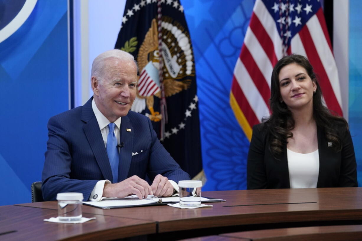 President Joe Biden, left, speaks as he sits next to Jennifer Arniella, right, owner of Unique Crafts by Jenn, during a meeting with small business owners in the South Court Auditorium on the White House complex in Washington, Thursday, April 28, 2022.