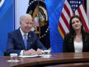 President Joe Biden, left, speaks as he sits next to Jennifer Arniella, right, owner of Unique Crafts by Jenn, during a meeting with small business owners in the South Court Auditorium on the White House complex in Washington, Thursday, April 28, 2022.