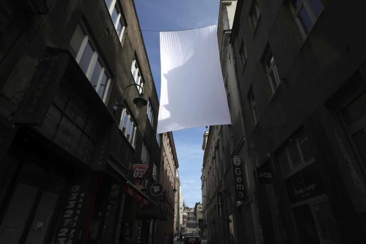 A cloth representing sniper protection screen is displayed in downtown in Sarajevo, Bosnia, Monday, April 4, 2022. Sarajevo is paying a subdued tribute to the resilience of its citizens who survived the longest military siege in modern history, and commemorating thousands of others who did not. Many of the survivors said they found the 30th anniversary of the start of the siege of the Bosnian capital particularly hard because they are marking it against the backdrop of what they describe as similar suffering being inflicted on civilians in Ukraine by Russia's occupying army.