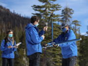 FILE - In this photo provided by the California Department of Water Resources, left, to right, Lauren Alkire, Nick Ellis, and Sean de Guzman, manager of snow surveys and water supply forecasting unit, conduct the third snow survey of the season at Phillips Station near Echo Summit, Calif., March 1, 2022. The department will conduct a manual measurement on a snow course in the Sierra Nevada on Friday, April 1, 2022, and announce the status of the statewide snowpack after historically dry winter conditions.