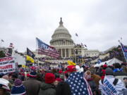 FILE - Rioters loyal to President Donald Trump rally at the U.S. Capitol in Washington on Jan. 6, 2021. A federal judge is set to deliver a verdict in the trial of a New Mexico man who claims a police officer waved him into the U.S. Capitol building after a riot erupted on Jan. 6, 2021. U.S. District Judge Trevor McFadden didn't immediately rule on Wednesday after hearing attorneys' closing arguments in the trial of Matthew Martin. McFadden heard testimony without a jury after Martin's trial started on Tuesday. He is expected to announce a verdict on Wednesday afternoon.