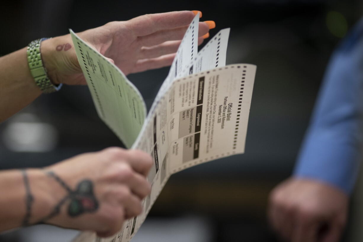 FILE - Poll workers sort out early and absentee ballots at the Kenosha Municipal building on Election Day in Kenosha, Wis., on Nov. 3, 2020. Wisconsin's Supreme Court is scheduled to hear arguments Wednesday, April 13, 2022, in a case that will likely determine how extensively absentee ballot drop boxes can be used in the upcoming midterm election where the battleground state's Democratic governor and Republican U.S. senator are on the ballot.