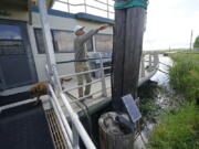 Ted Falgout points out the storm's waterline standing on the houseboat on his property that he rode out Hurricane Ida and has been living in while his home undergoes extensive repairs, in Larose, La., Thursday, April 14, 2022. As climate change increases the threat of hurricanes, cities on the Louisiana coast and Mississippi River are hoping President Biden's $1.2 trillion infrastructure package will provide badly needed funding to fortify locks, levees and other flood protections.