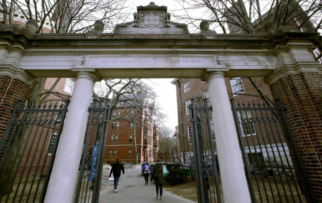 FILE - In this Dec. 13, 2018, file photo, a gate opens to the Harvard University campus in Cambridge, Mass.