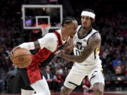 Portland Trail Blazers guard Keon Johnson, left, drives to the basket on Utah Jazz guard Jordan Clarkson, right, during the first half of an NBA basketball game in Portland, Ore., Sunday, April 10, 2022.