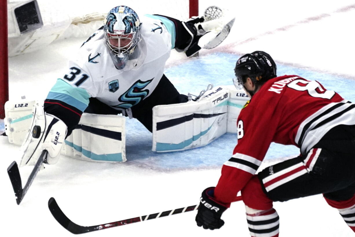 Seattle Kraken goaltender Philipp Grubauer, left, saves a shot by Chicago Blackhawks left wing Dominik Kubalik during the third period of an NHL hockey game in Chicago, Thursday, April 7, 2022. The Kraken won 2-0. (AP Photo/Nam Y.