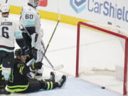 Dallas Stars center Roope Hintz (24) sits on the ice after he scored a goal against Seattle Kraken goaltender Chris Driedger (60) and defenseman Adam Larsson (6) during the second period of an NHL hockey game in Dallas, Saturday, April 23, 2022.