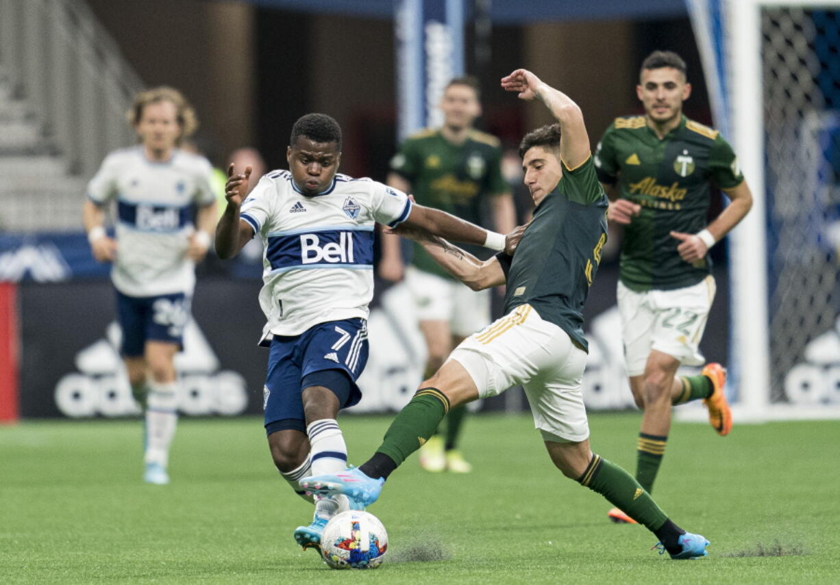 Portland Timbers defender Claudio Bravo (5) tries to breaks up the run of Vancouver Whitecaps forward D?iber Caicedo (7) during the first half of an MLS soccer match Saturday, April 9, 2022, in Vancouver, British Columbia.