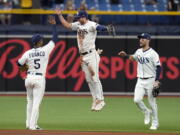 Tampa Bay Rays left fielder Brett Phillips, center, celebrates with shortstop Wander Franco, left, and center fielder Kevin Kiermaier, right, after the team defeated the Seattle Mariners during a baseball game Thursday, April 28, 2022, in St. Petersburg, Fla.