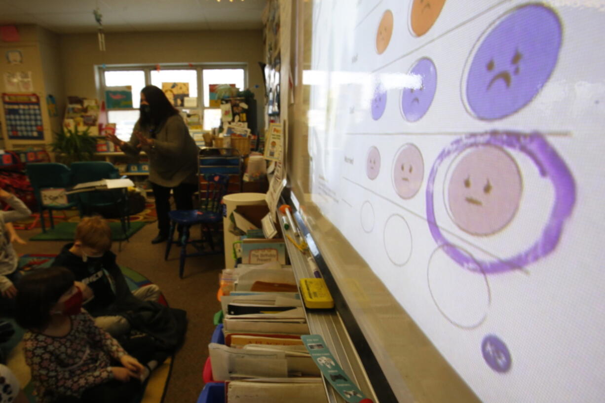 FILE - Second-grade teacher Melissa Shugg teaches a lesson at Paw Paw Elementary School about thoughts, feelings and actions on Dec. 2, 2021, in Paw Paw, Michigan. Shugg is one of many teachers at the school who've been trained to teach a social-emotional curriculum created at the University of Michigan called TRAILS. Research suggests TRAILS lessons for at-risk kids can reduce depression and improve coping skills -- something district officials say has been particularly important during the pandemic.