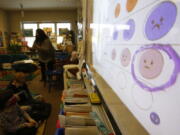 FILE - Second-grade teacher Melissa Shugg teaches a lesson at Paw Paw Elementary School about thoughts, feelings and actions on Dec. 2, 2021, in Paw Paw, Michigan. Shugg is one of many teachers at the school who've been trained to teach a social-emotional curriculum created at the University of Michigan called TRAILS. Research suggests TRAILS lessons for at-risk kids can reduce depression and improve coping skills -- something district officials say has been particularly important during the pandemic.