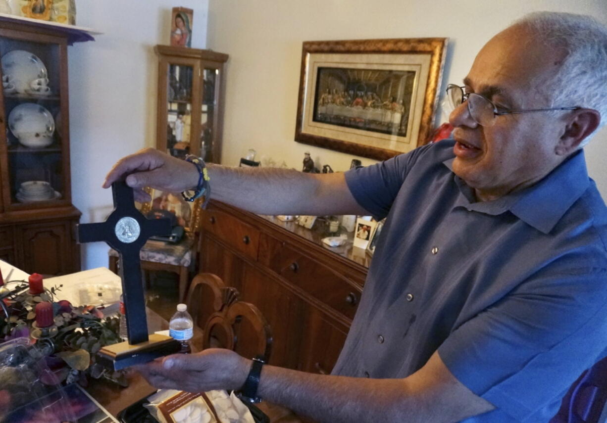 Bob Guerra, a Catholic deacon, holds a crucifix he got to commemorate the visit of Pope Francis to the U.S.-Mexican border at his house April 3 in El Paso, Texas.