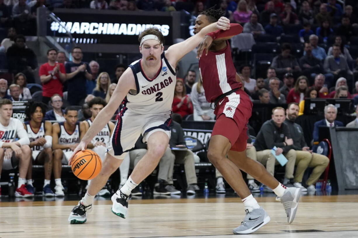 Gonzaga forward Drew Timme, left, drives to the basket against Arkansas guard Stanley Umude during the second half of a college basketball game in the Sweet 16 round of the NCAA tournament in San Francisco, Thursday, March 24, 2022.