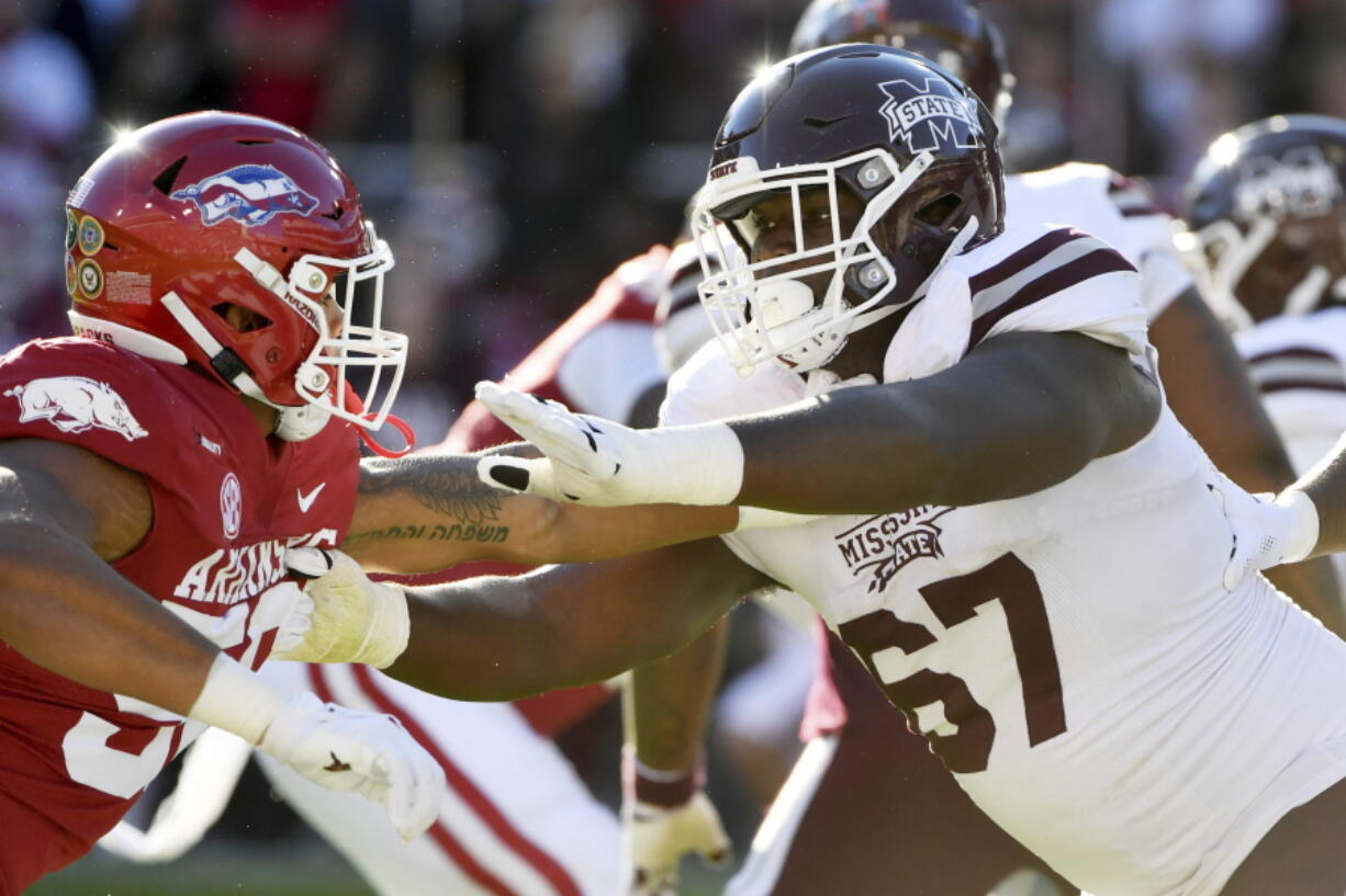 FILE - Mississippi State offensive lineman Charles Cross (67) blocks against Arkansas during an NCAA college football game Nov. 6, 2021, in Fayetteville, Ark. Cross was selected by the Seattle Seahawks during the first round of the NFL draft Thursday, April 28.