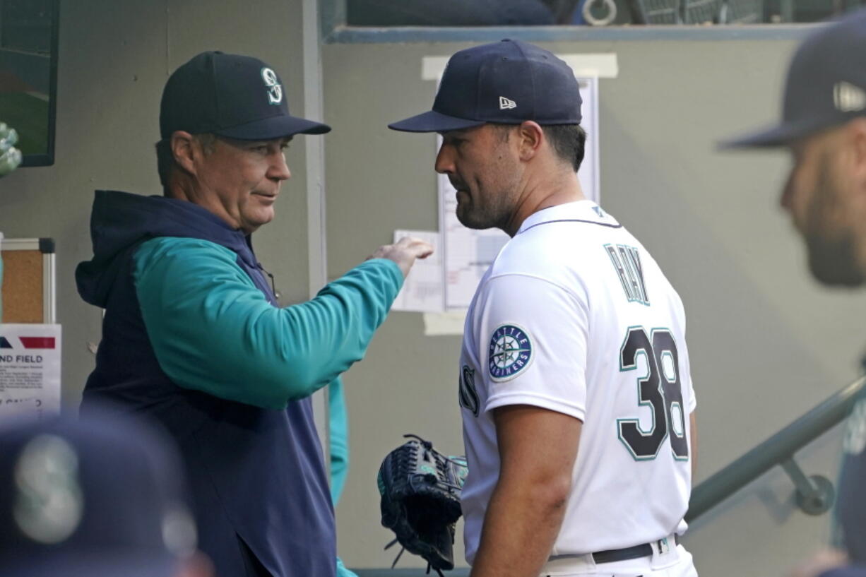 Seattle Mariners starting pitcher Robbie Ray, right, talks with manager Scott Servais in the dugout before the team's baseball game against the Texas Rangers, Tuesday, April 19, 2022, in Seattle. (AP Photo/Ted S.